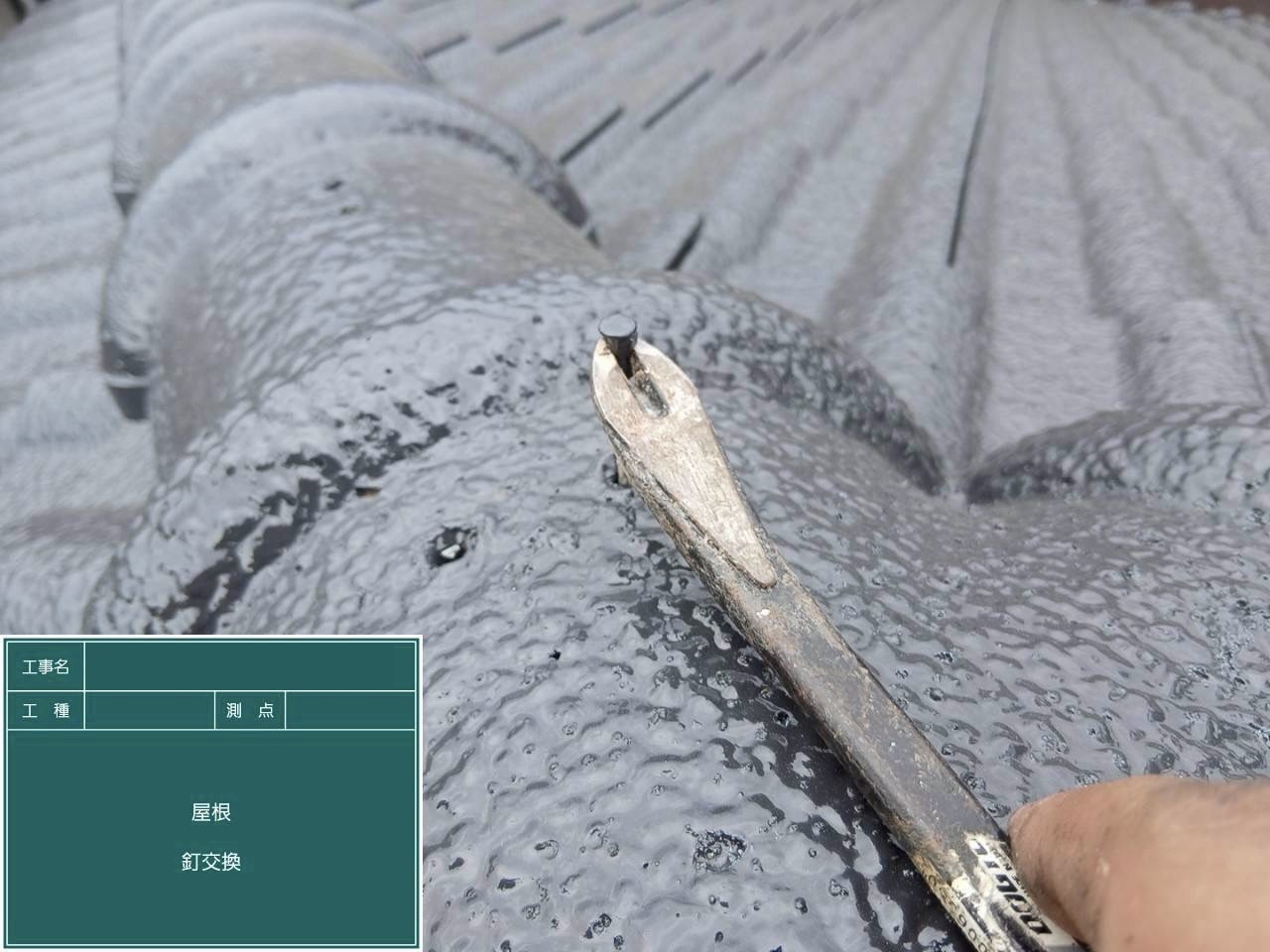 黒い棟瓦の古い固定釘を抜いている